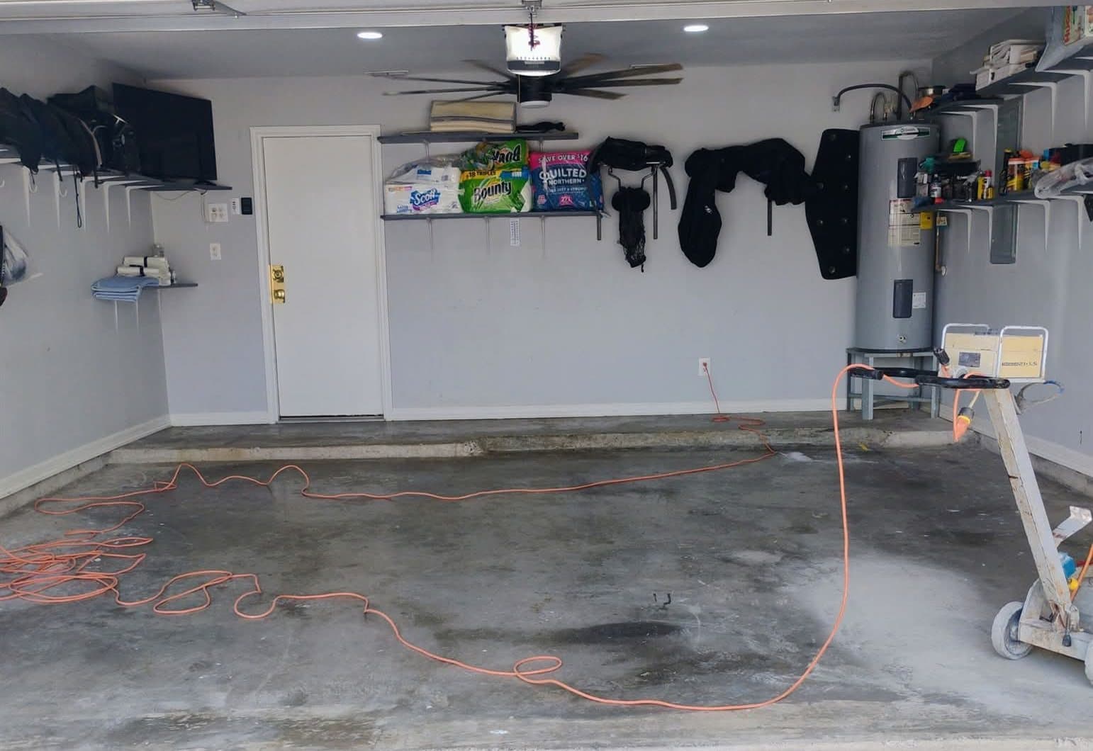 Bare, stained concrete slab in a two-car garage before treatment.