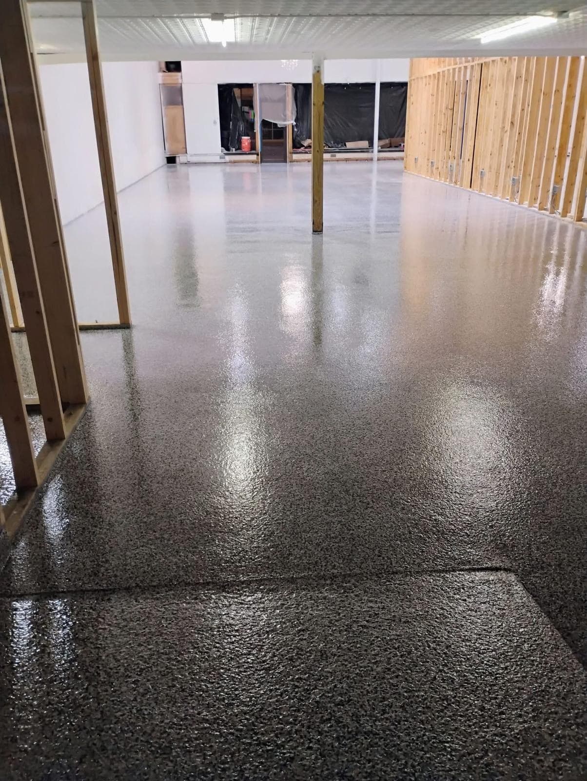 Grey flake floor running the length of a large open commercial space during fit-out.
